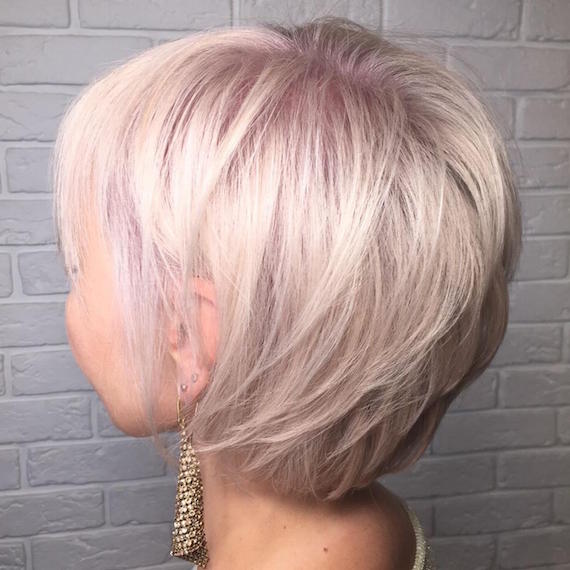 Side profile of woman with short blush blonde pixie cut, created using Wella Professionals.