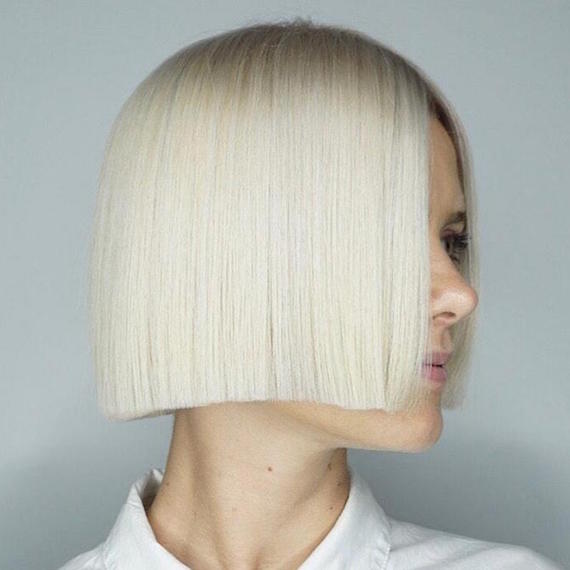 Side profile of woman with short platinum blonde hair, created using Wella Professionals.