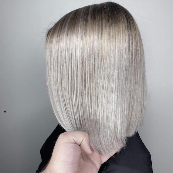 Side profile of woman with ice blonde bob, created using Wella Professionals.