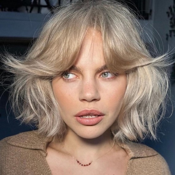 Model with a chin-length, blonde bob and a grown-out fringe.