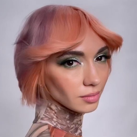 Model with pastel micro bob. The front half is peach and the back half is lavender.