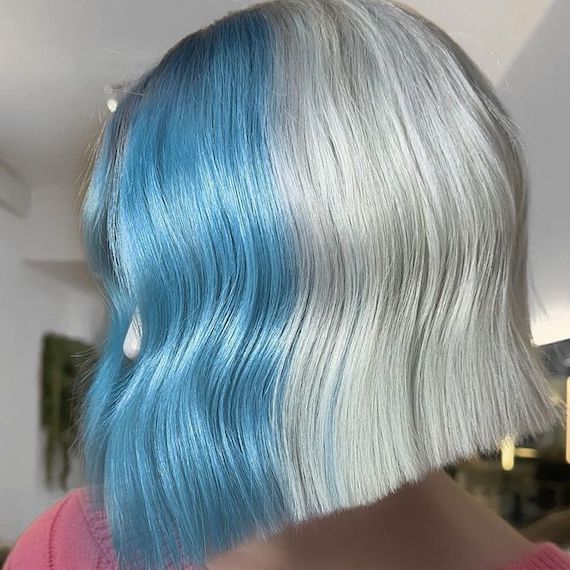 Side profile of model with graduated bob haircut. The front half is blue and the back half is silver blonde.