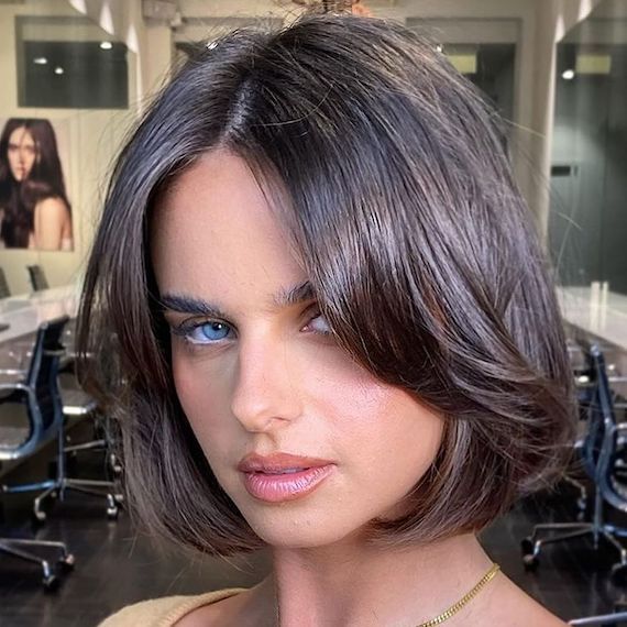 Model with glossy brown bob haircut and layering through the front.