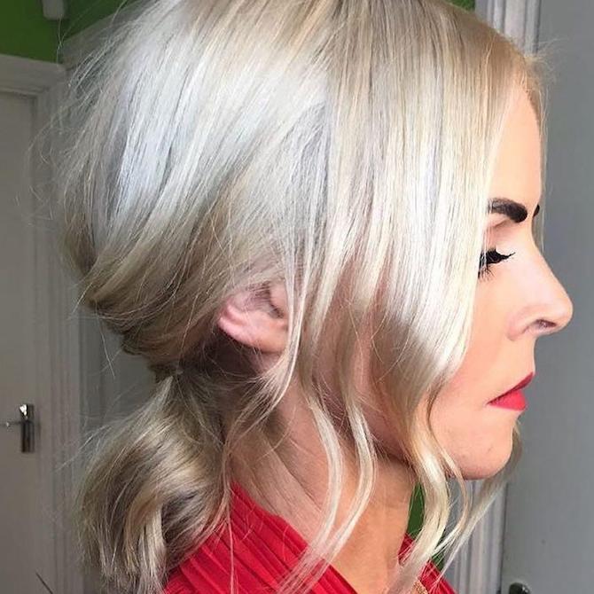 Side profile shot of woman with ice blonde, short hair pulled back into a low ponytail, created using Wella Professionals