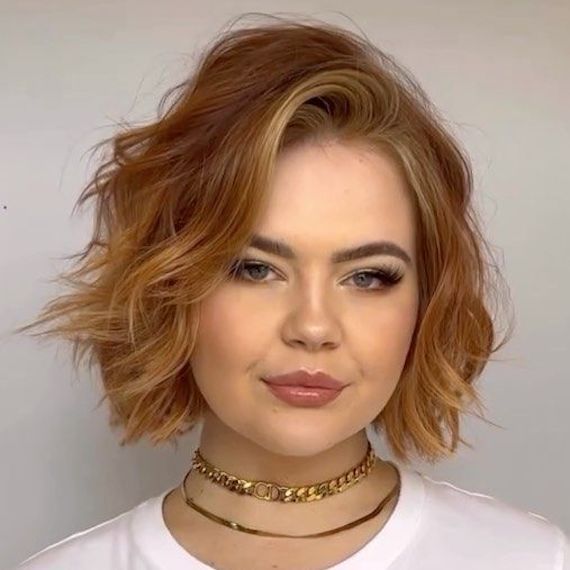 Model with wavy, copper red bob and cinnamon blonde highlights.