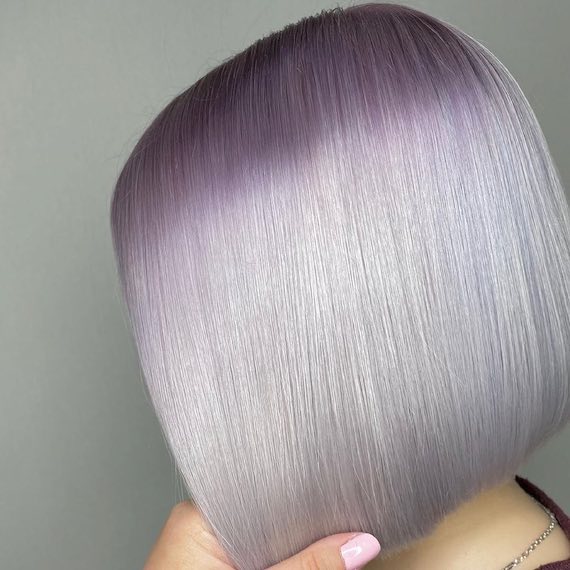 Model with short, blunt, purple to platinum ombre bob.