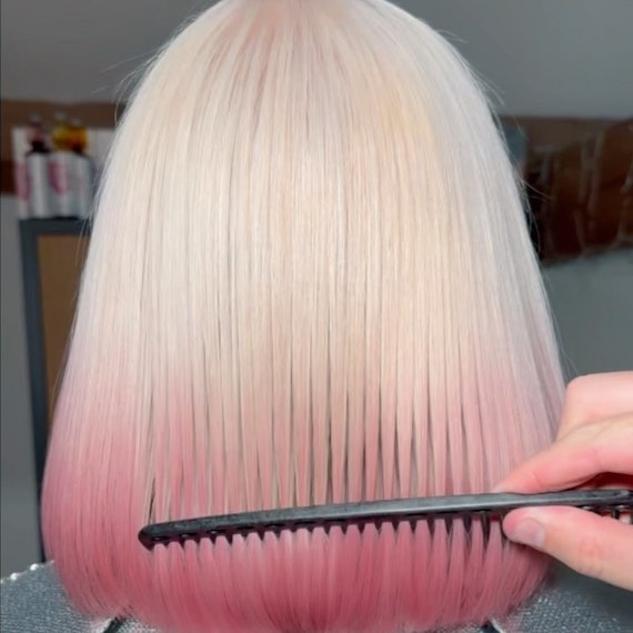 Model with platinum blonde bob featuring a coral pink ombre effectr.