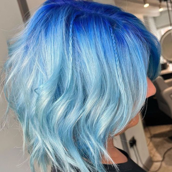 Model with short, layered bob featuring a cobalt to pastel blue ombre effect.