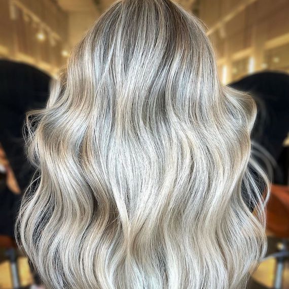 Back of model’s head with long, wavy, cool blonde hair.