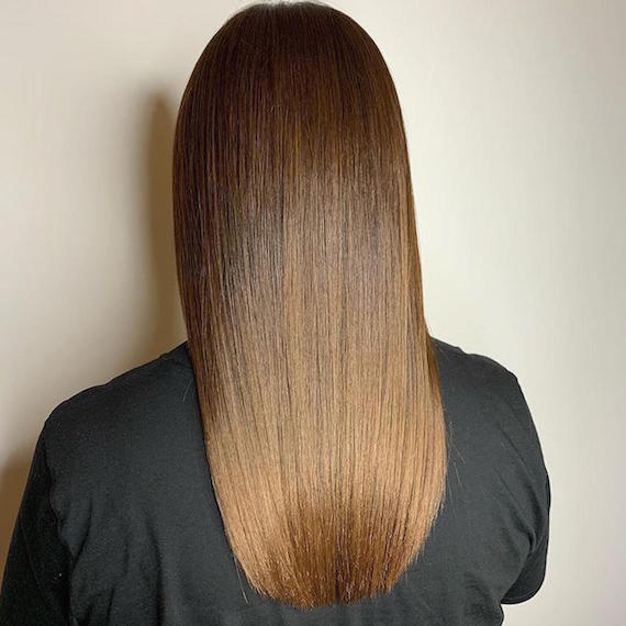 Back of woman’s head with long, straight, brown sombre hair, created using Wella Professionals.