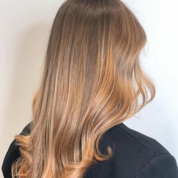 Back of woman’s head with light brown/dark blonde sombre hair, created using Wella Professionals.