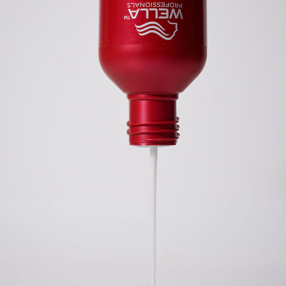 ULTIMATE REPAIR Shampoo is poured from bottle.