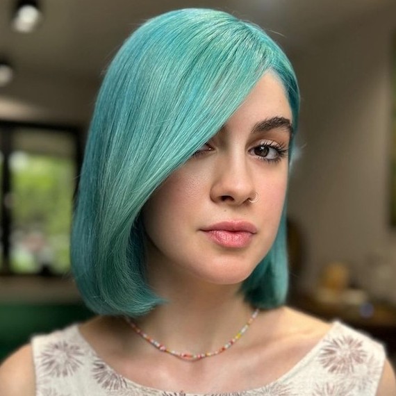 Model with bob haircut in a bold aqua shade.