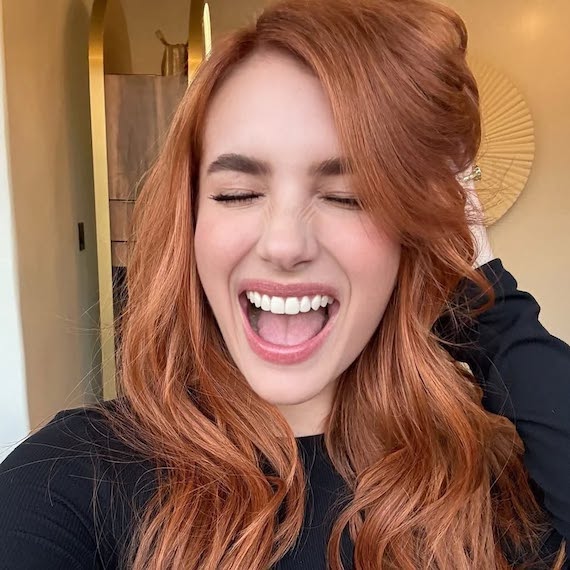 Emma Roberts with Sunrise Red hair styled in tousled waves.