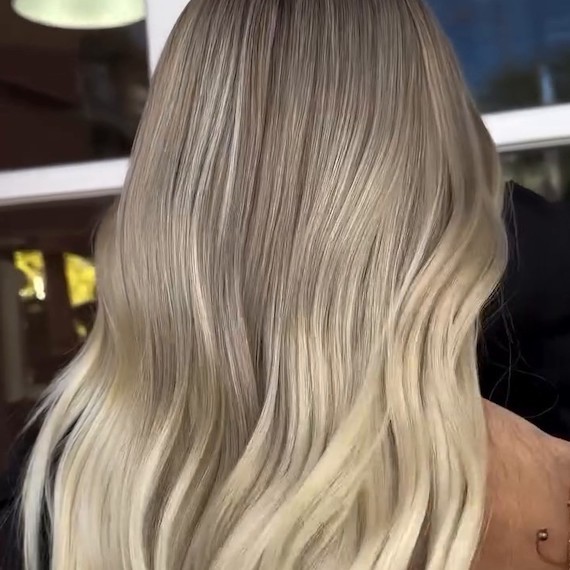 Back of model’s head with light blonde hair featuring an air touch balayage.