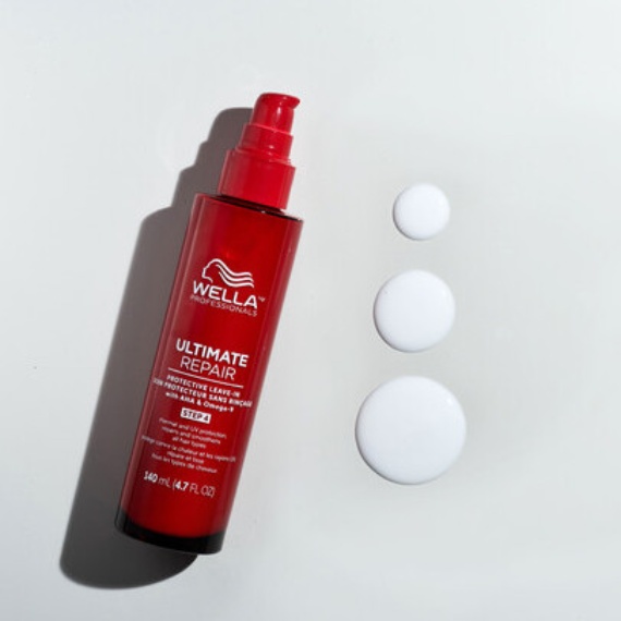 ULTIMATE REPAIR Protective Leave-In bottle next to drops of the delicate cream.