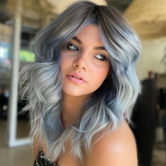 Model with beachy, wavy hair in shades of teal green and ocean blue.