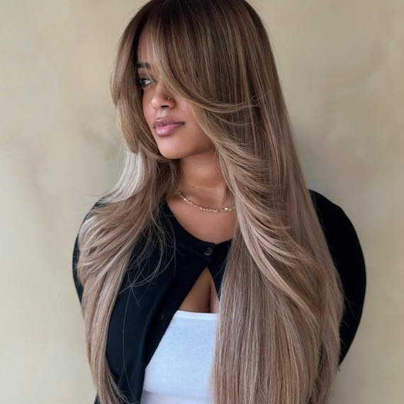 Model with ultra-long, dark brown hair featuring beige blonde balayage through the mid-lengths and ends.