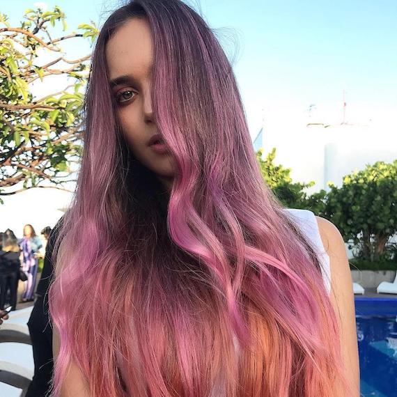 Woman with super-long, pink, wavy hair, styled using Wella Professionals