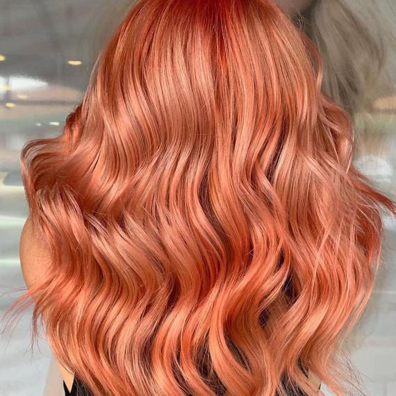 Back of a woman’s head showing wavy, peach hair, created using Wella Professionals