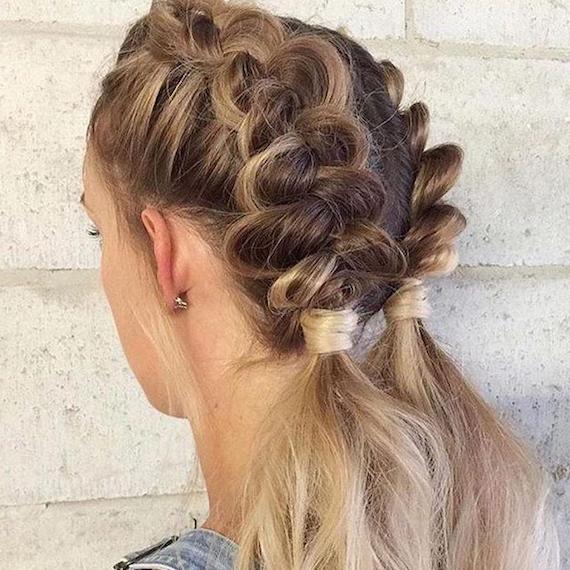 Back of a woman’s head showing blonde hair in braided bunches, styled using Wella Professionals