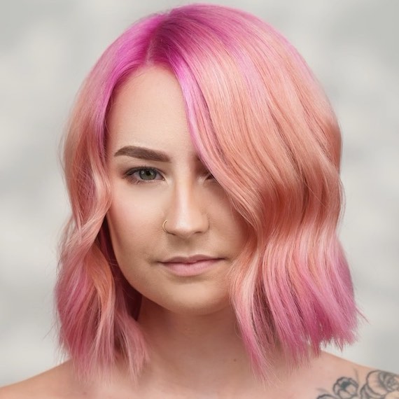 Model with bob haircut featuring a rose pink and golden blonde ombre effect.