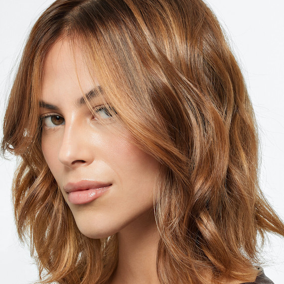 Model with shoulder-length, light brown hair featuring golden blonde, melted highlights.