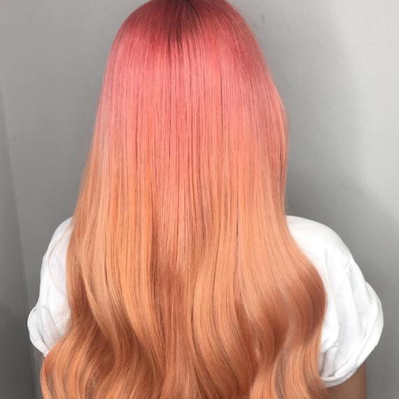 Back of woman’s head with long, blow-dried, pink to peach ombre hair, created using Wella Professionals.