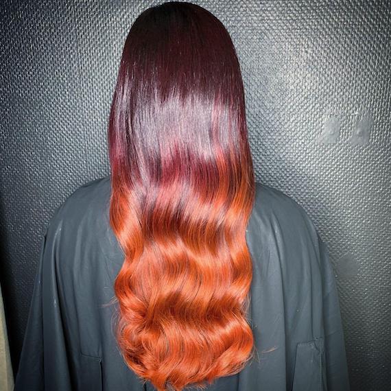 Back of woman’s head with long, wavy, red to copper ombre hair, created using Wella Professionals.
