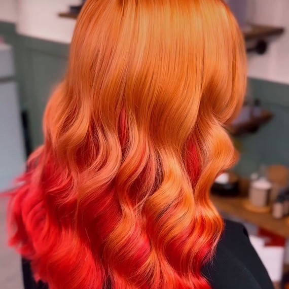 Back of model’s head with long, copper hair featuring red tones painted through the mid-lengths and ends.