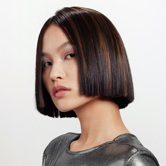 Model with dark brown, ultra-short bob haircut featuring caramel highlights.