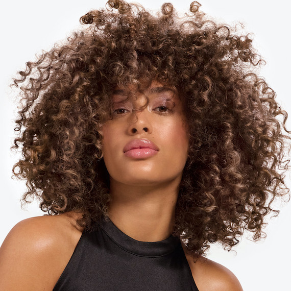 Model with full, voluminous, curly bronde hair.