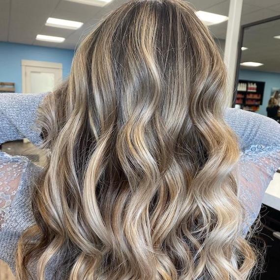 Back of woman’s head with long, wavy, ash blonde hair and teasy lights, created using Wella Professionals.
