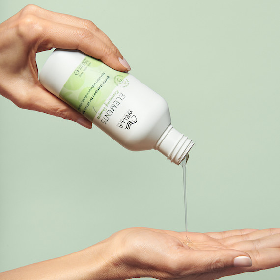 Elements Renewing Shampoo is poured into a hand. 