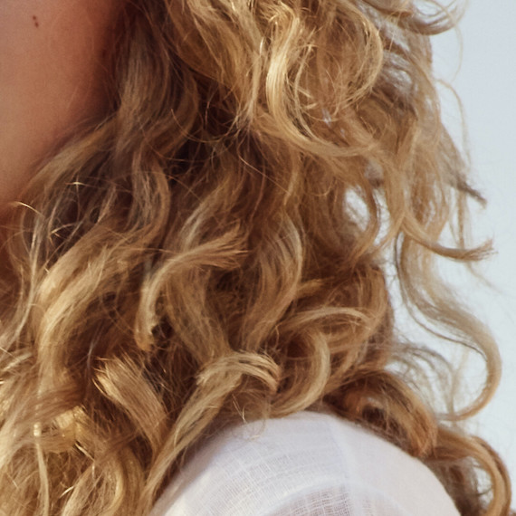 Close-up of model’s blonde, curly hair.