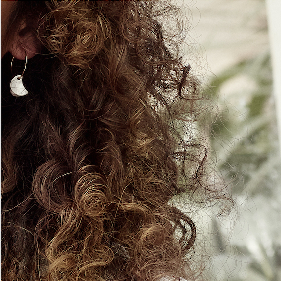 Close-up of model’s dark brown, curly hair.