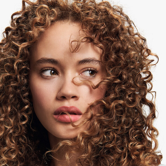 Model with golden brown, curly hair.