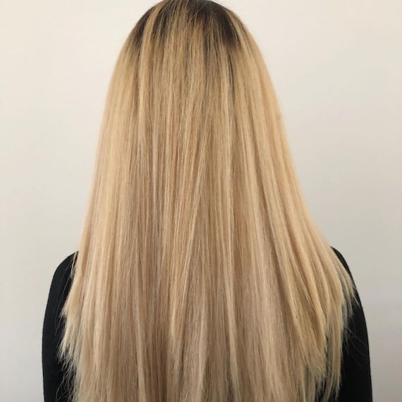 Back of woman’s head with long, yellow blonde hair.