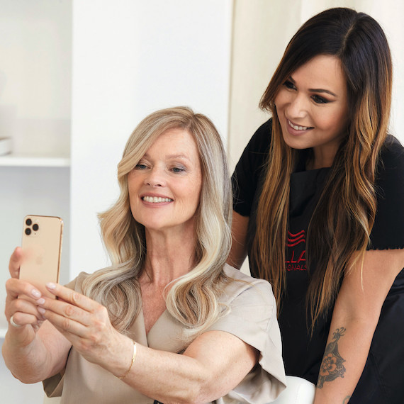 Frau macht ein Selfie mit ihrem Friseur.