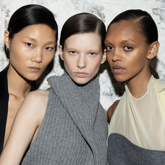 Three models face the camera backstage at Victoria Beckham’s Paris Fashion Week show.