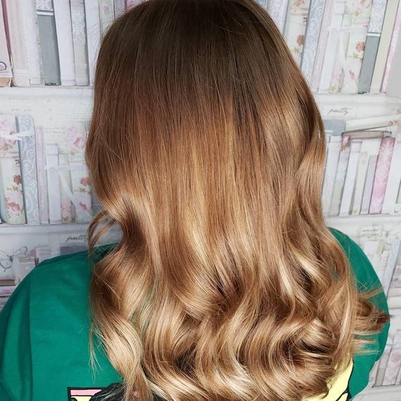 Photo showing the back of a woman’s head with long, loosely-curled, bronde hair. Created using Wella Professionals