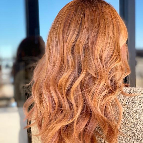 Photo showing the back of a woman’s head with long, wavy, strawberry blonde hair. Created using Wella Professionals. 