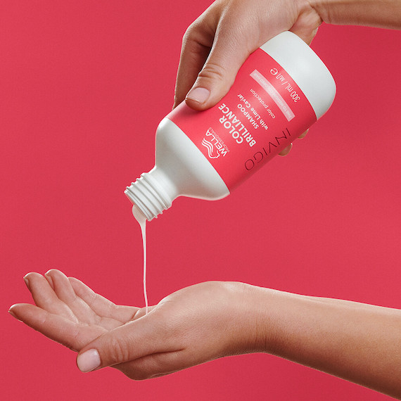 INVIGO Color Brilliance Color Protection Shampoo is poured into model’s hand.
