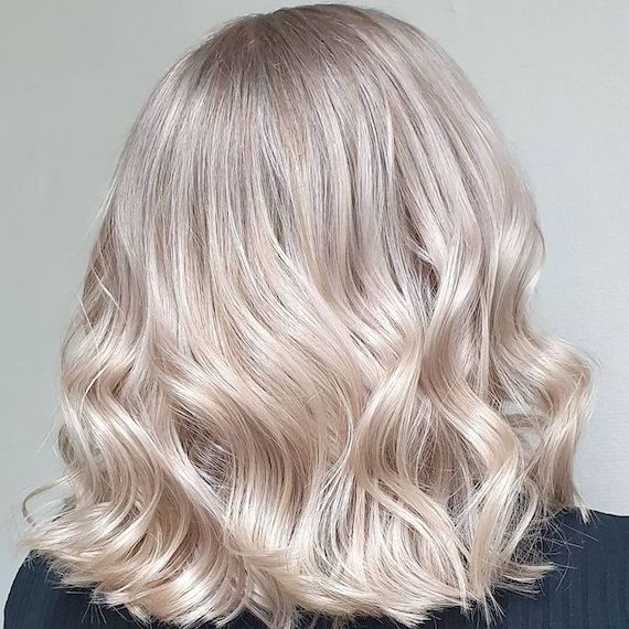 Back of woman’s head with loosely curled, ice blonde hair.