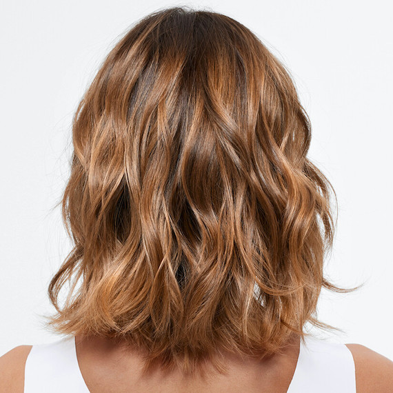 Back of model’s head with caramel brown-blonde, wavy hair.