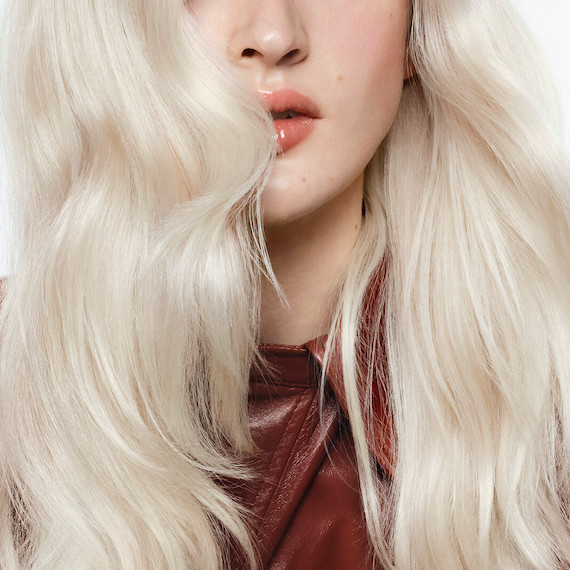 Close-up of model’s long, wavy, platinum vanilla blonde hair.