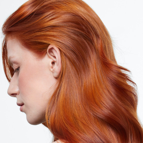 Side profile of model with pumpkin spice and bold copper hair.