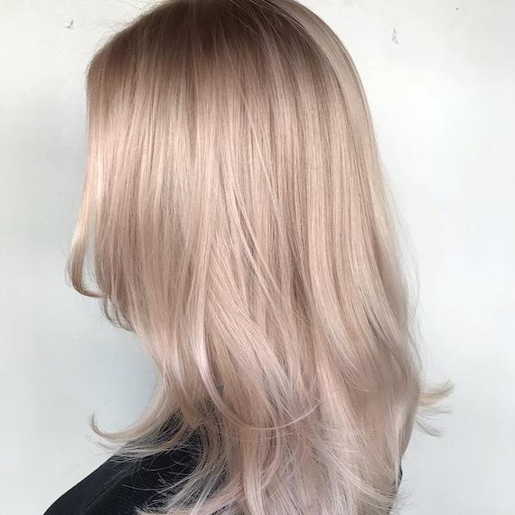 Side profile shot of woman with straight, ash blonde hair, created using Wella Professionals
