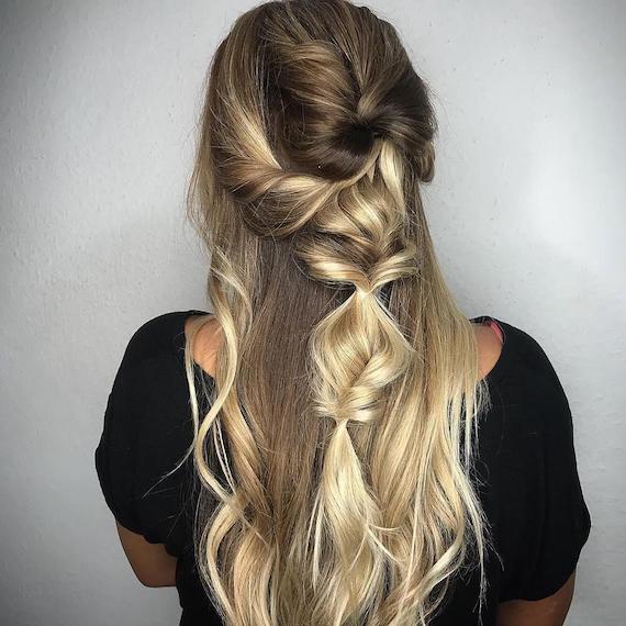 Back of woman’s head with long hair styled in tousled fishtail braids