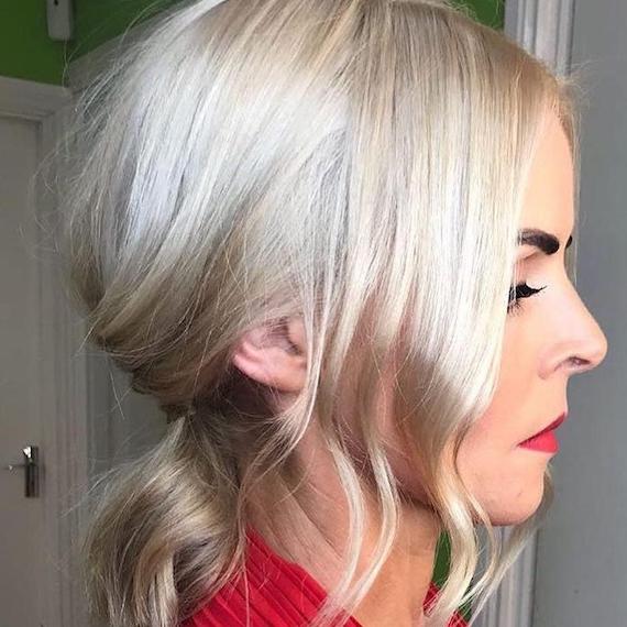 Side profile of woman with icy blonde hair styled in a low ponytail